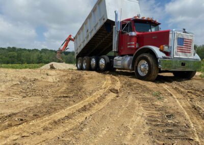 Dump truck unloading sand at a project site