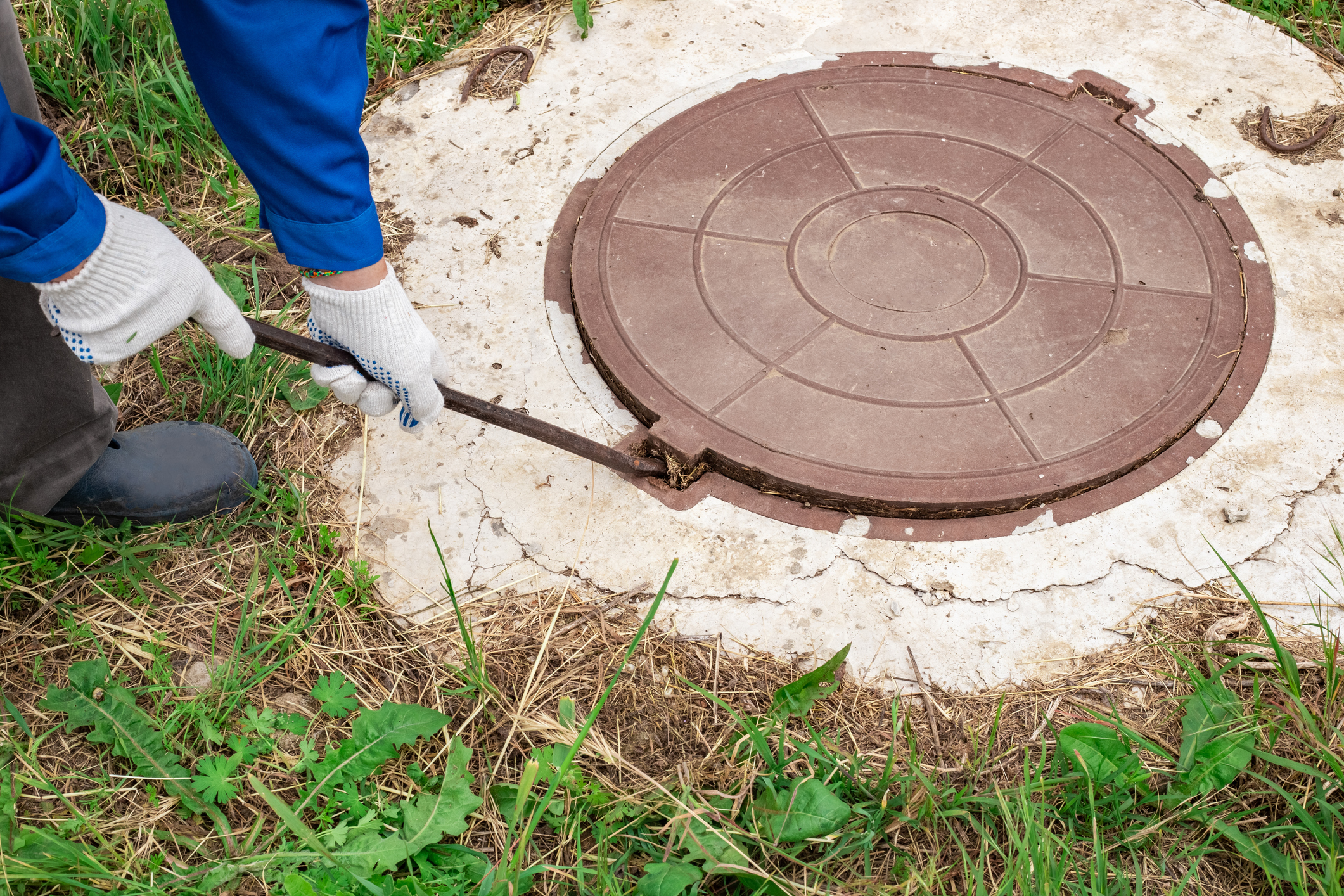 the worker opens the manhole cover to inspect and check the equipment